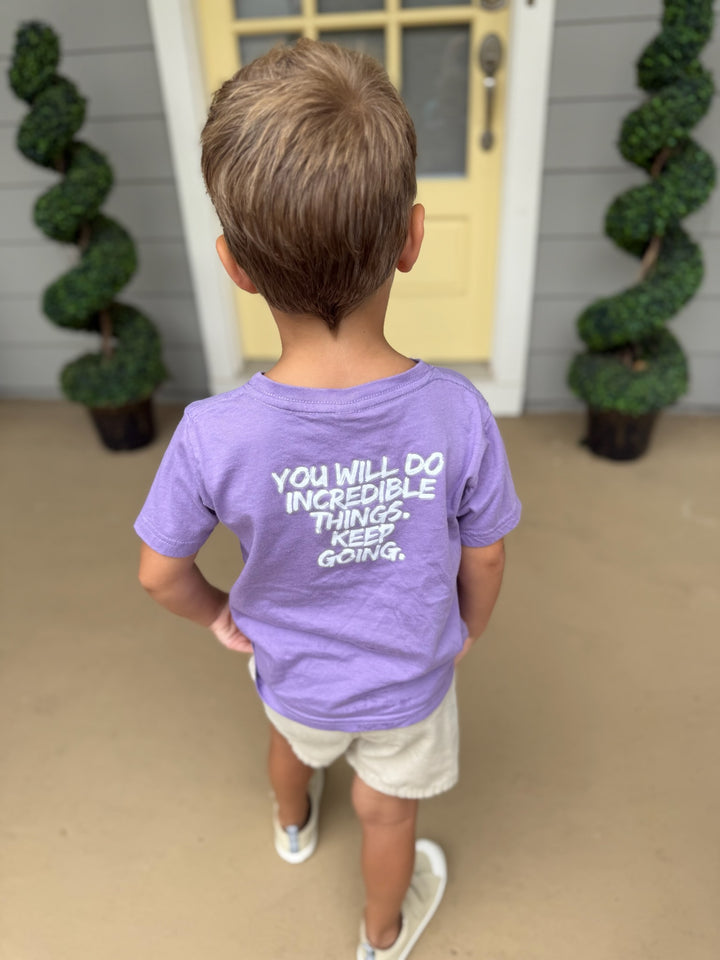Child wearing The Incredible Toddler Tee - Kids Violet T-Shirt and showing the Motivational "YOU WILL DO INCREDIBLE THINGS. KEEP GOING." Motto
