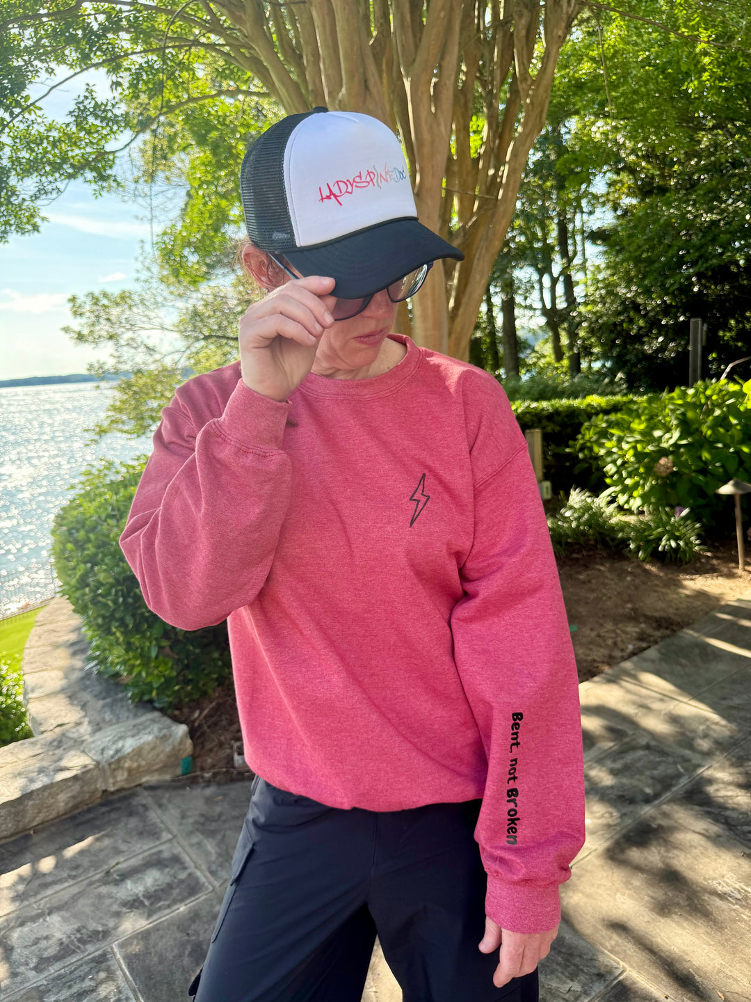 Ladyspinedoc wearing her Bent Not Broken Scoliosis Crewneck Sweatshirt – Heather Red. Also wearing a Ladyspinedoc trucker hat.