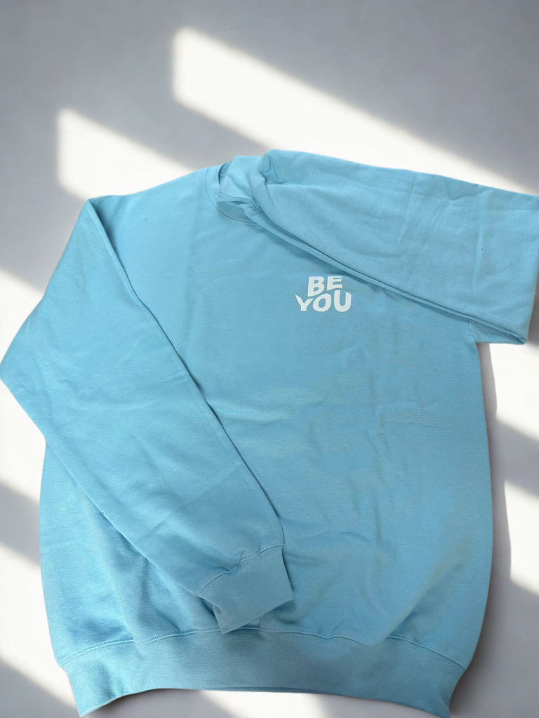 Light blue crewneck sweatshirt with "Be You" text on upper left front chest