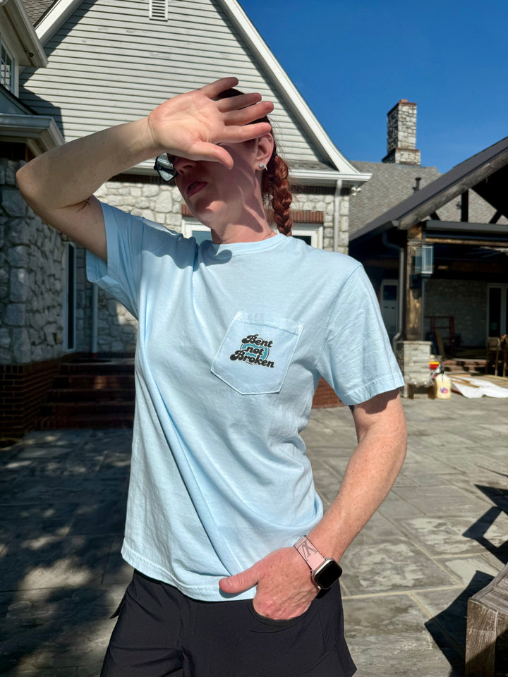 Ladyspinedoc wearing her Bent, Not Broken Scoliosis Awareness Tee - Blue Cotton T-Shirt, showing the pocket
 with the Bent not Broken catchphrase.