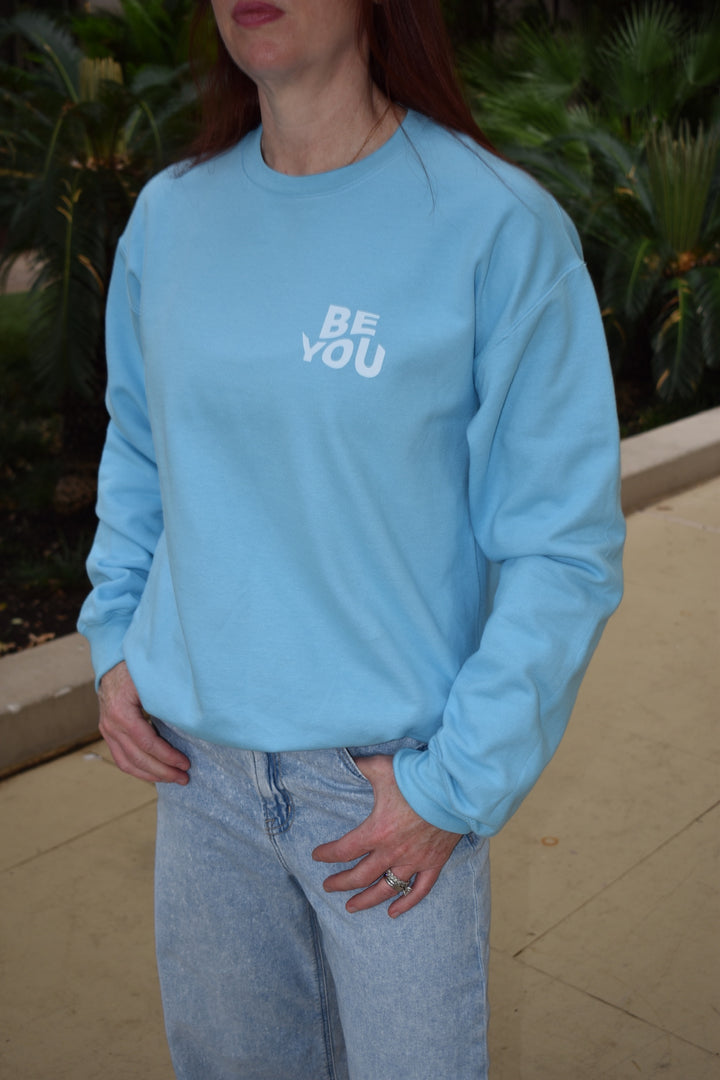 Dr. Betsy Grunch (Ladyspinedoc) wearing the light blue Be You sweatshirt showing the "Be You" motton on the upper left chest.