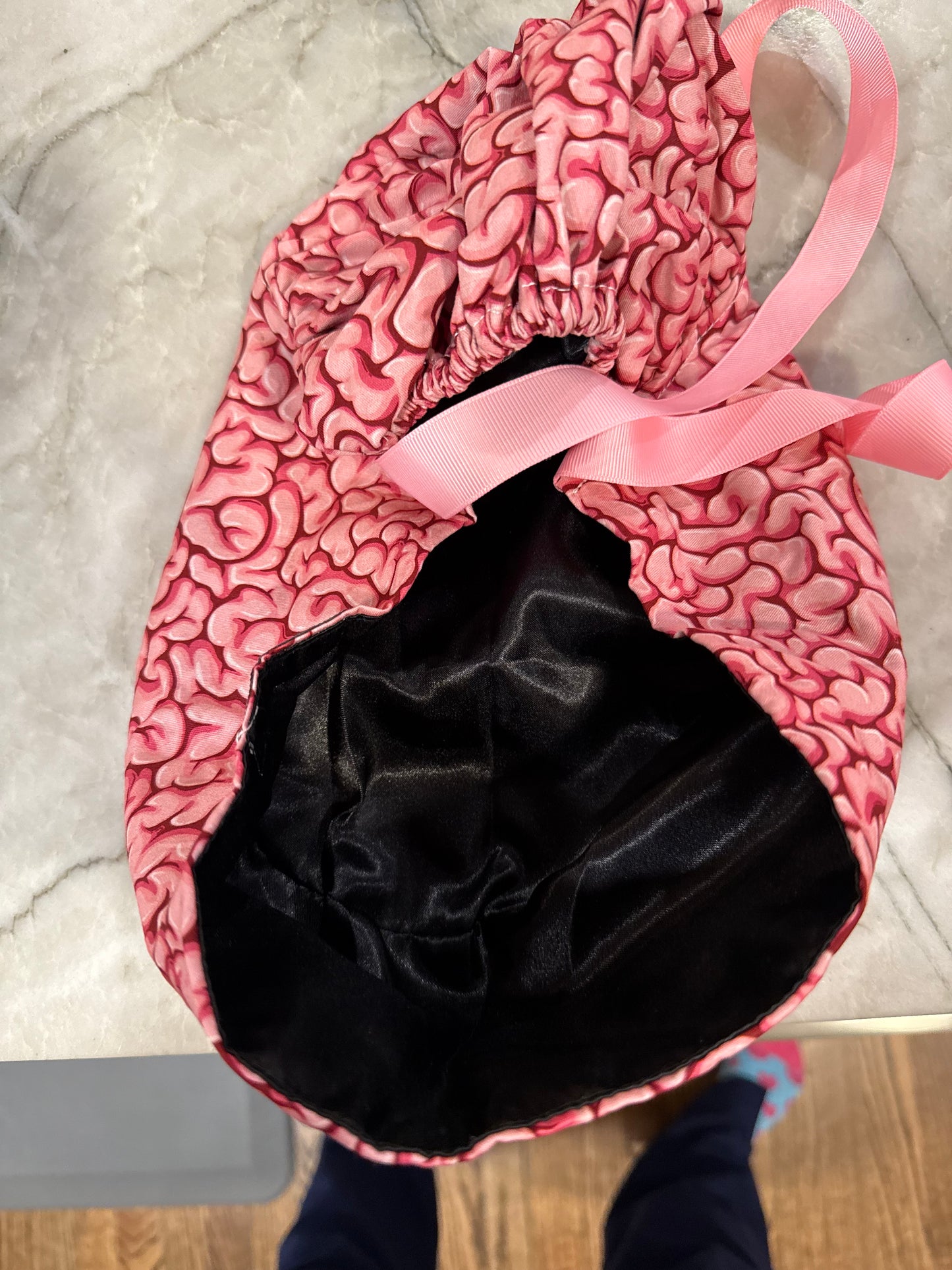 Flat lay of the opening of the Cortex Cap - Pink Scrub Hat with Brain Design showing the satin lining