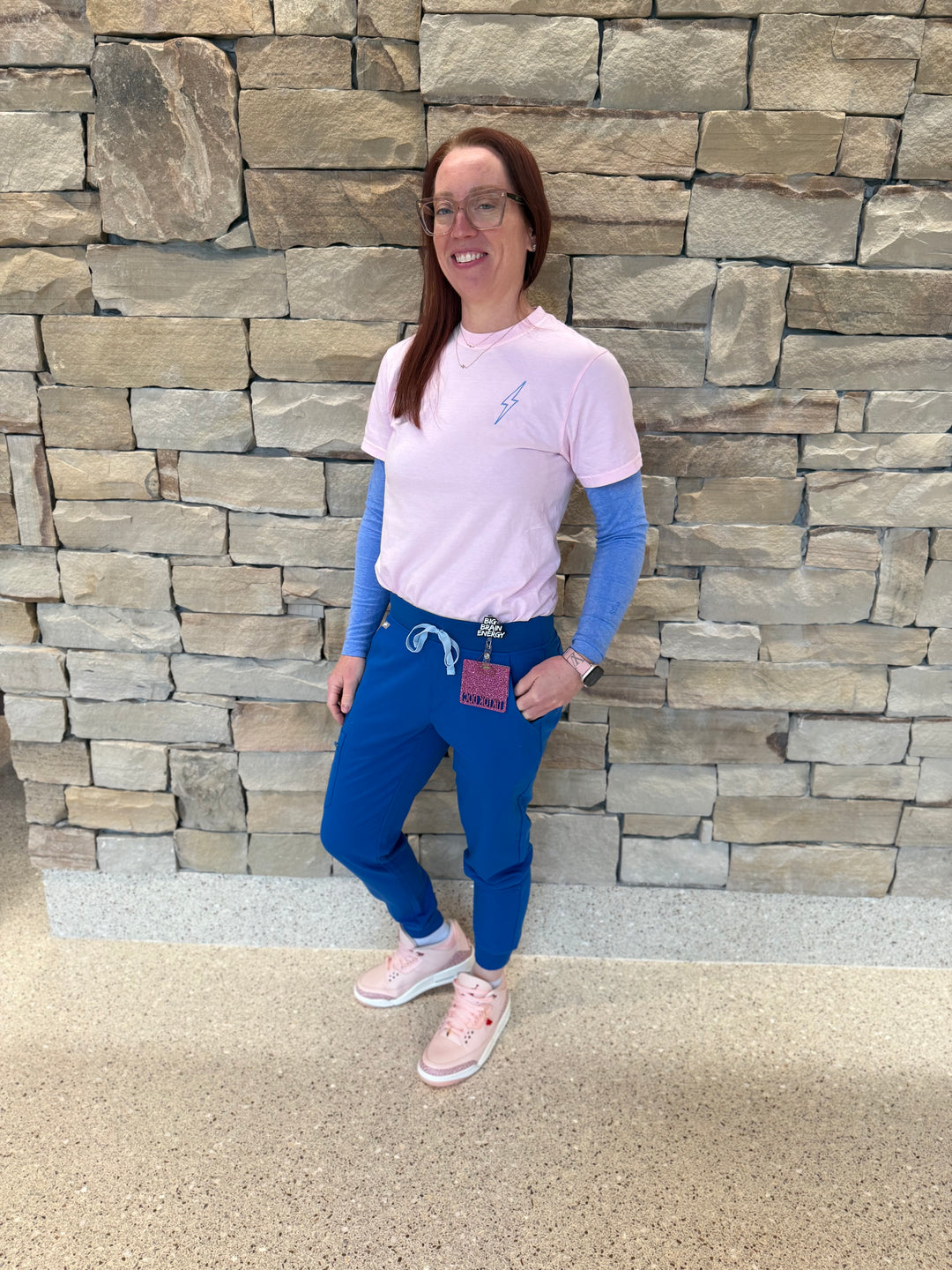 Front view of Dr. Betsy Grunch (Ladyspinedoc) wearing the light pink lumbar puncture tee shirt with lightning bolt on upper left chest.