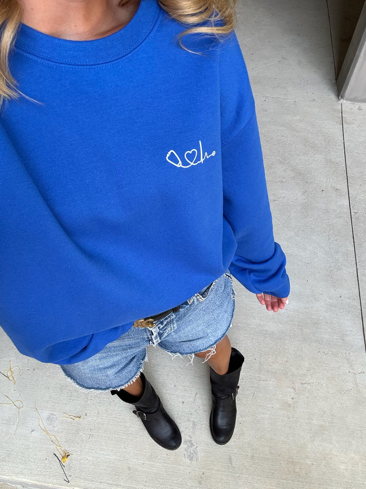 Front view of model wearing Dr. Beachgem Heart of Medicine Crewneck Sweatshirt - Royal Blue