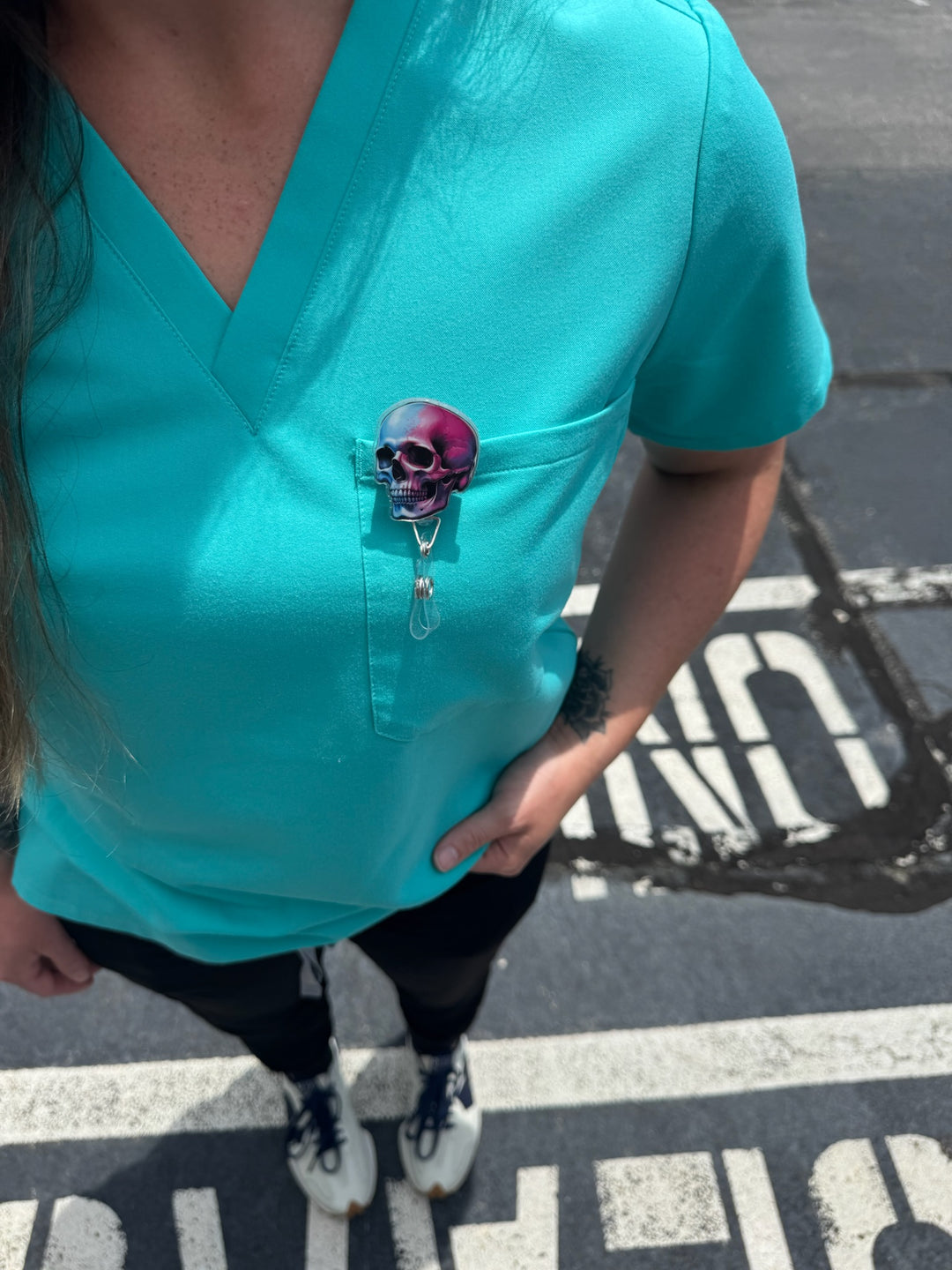 Super Skull Badge Reel - Retractable with Alligator Clip and Colorful Skull Design clipped on front pocket of woman's scrubs