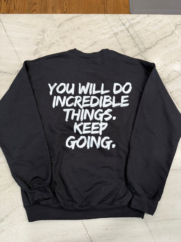 Back flat lay of the black Incredible Youth Crewneck Sweatshirt with bold white brushstroke message: "YOU WILL DO INCREDIBLE THINGS. KEEP GOING."