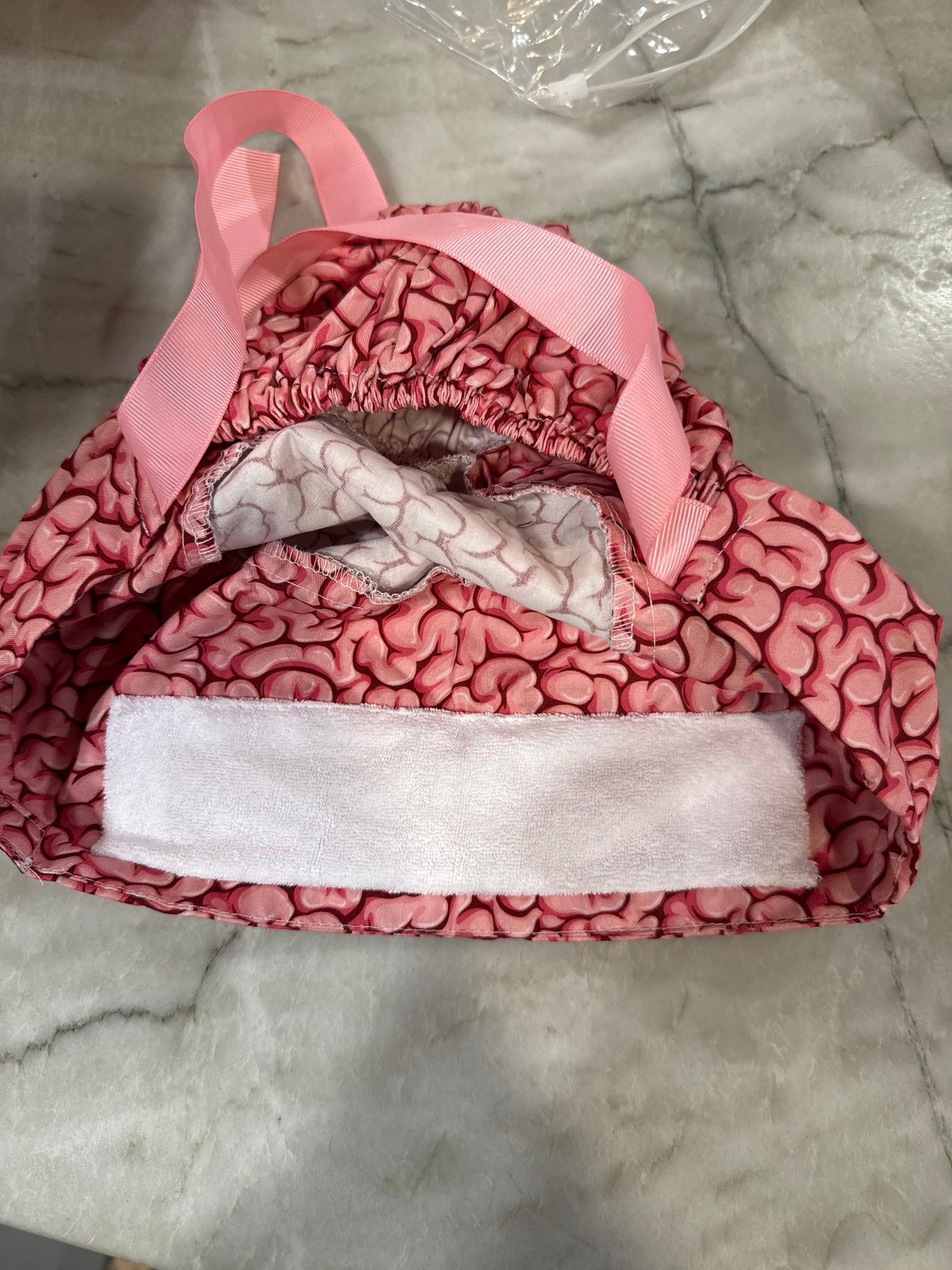 Flat lay of the opening of the Cortex Cap - Pink Scrub Hat with Brain Design showing the small sweatband inside