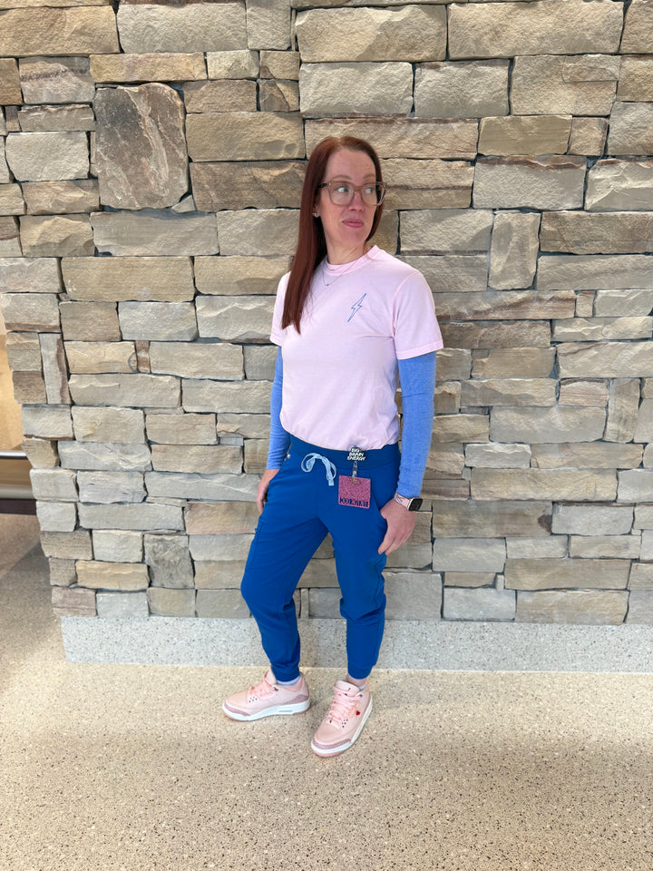 Dr. Betsy Grunch (Ladyspinedoc) wearing and showing off the front of the light pink lumbar puncture tee shirt.