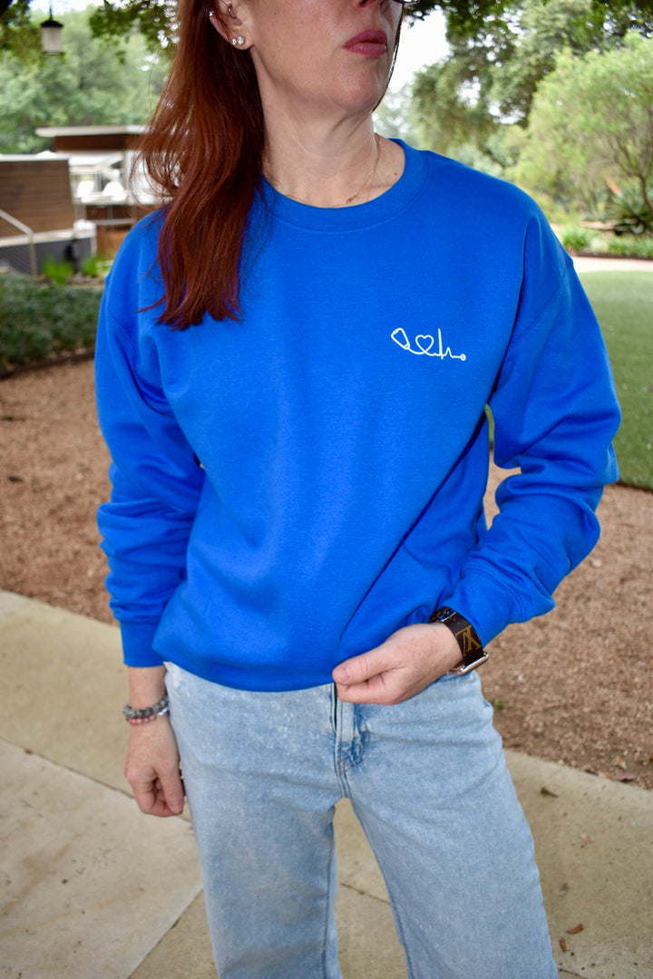 Close up front view of Dr. Betsy Grunch (Ladyspinedoc) wearing the Heart of Medicine sweatshirt in royal blue