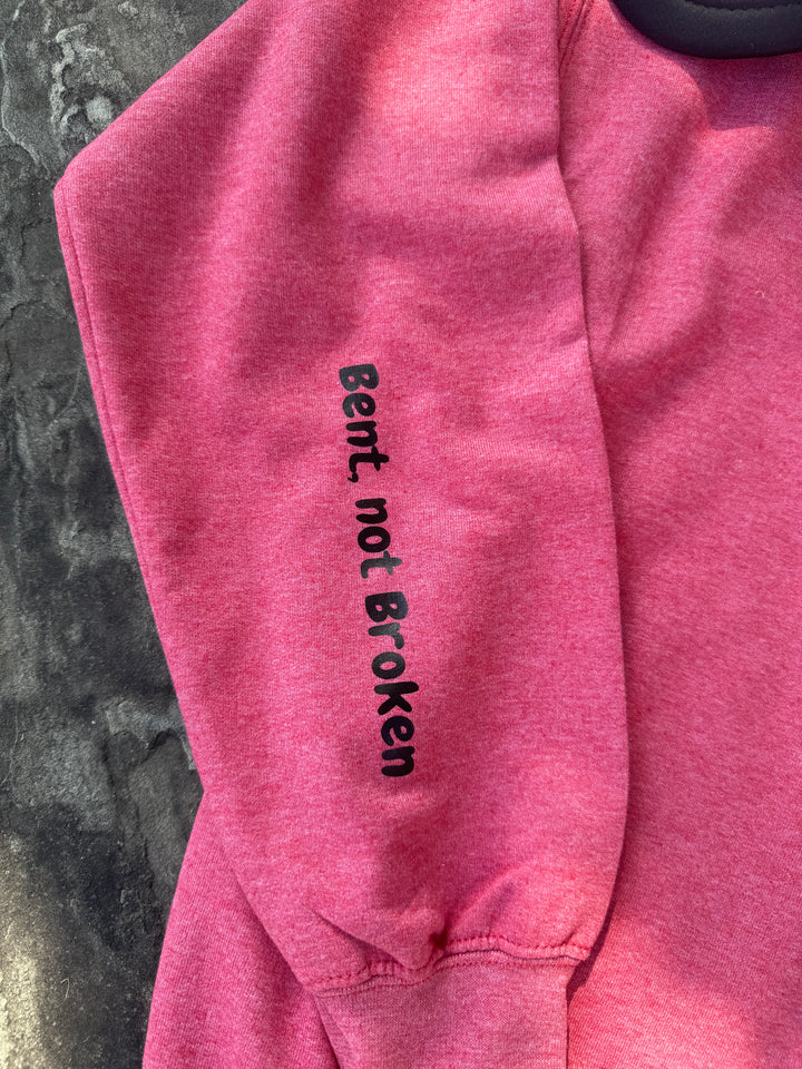Close up view of the motto on sleeve of the Bent Not Broken Scoliosis Crewneck Sweatshirt.