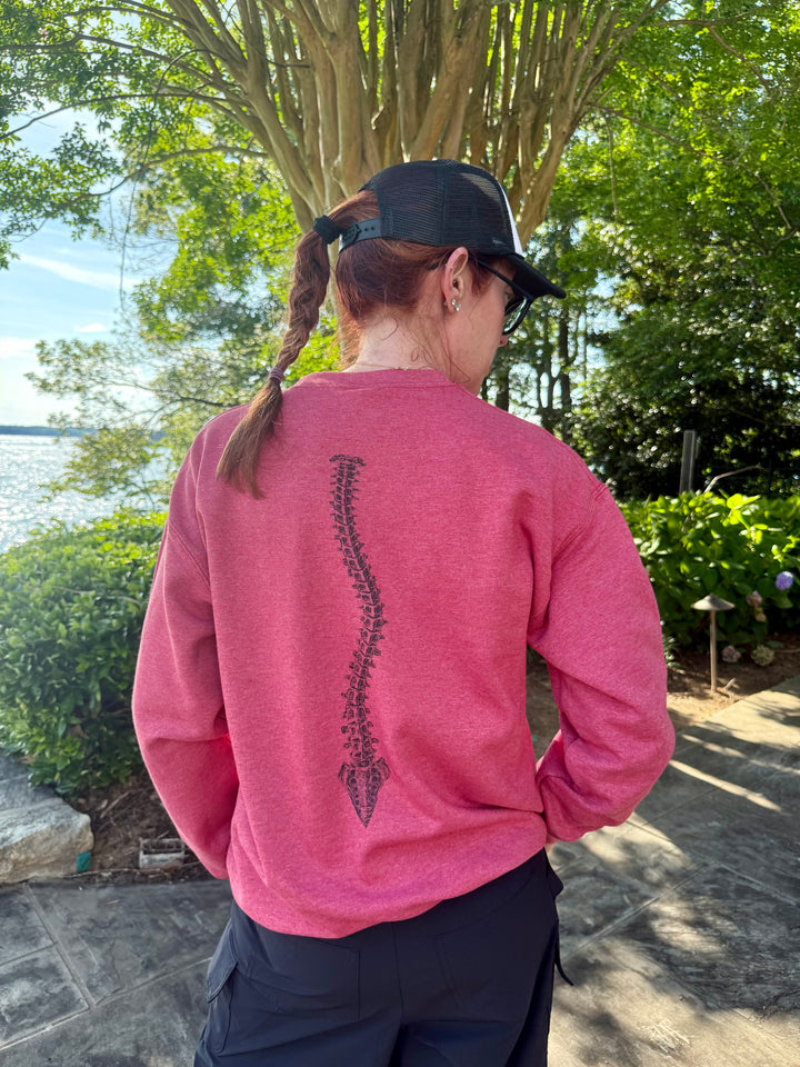 Dr. Betsy Grunch wearing her red Bent Not Broken Scoliosis Crewneck Sweatshirt and showing off the back curved spine design.