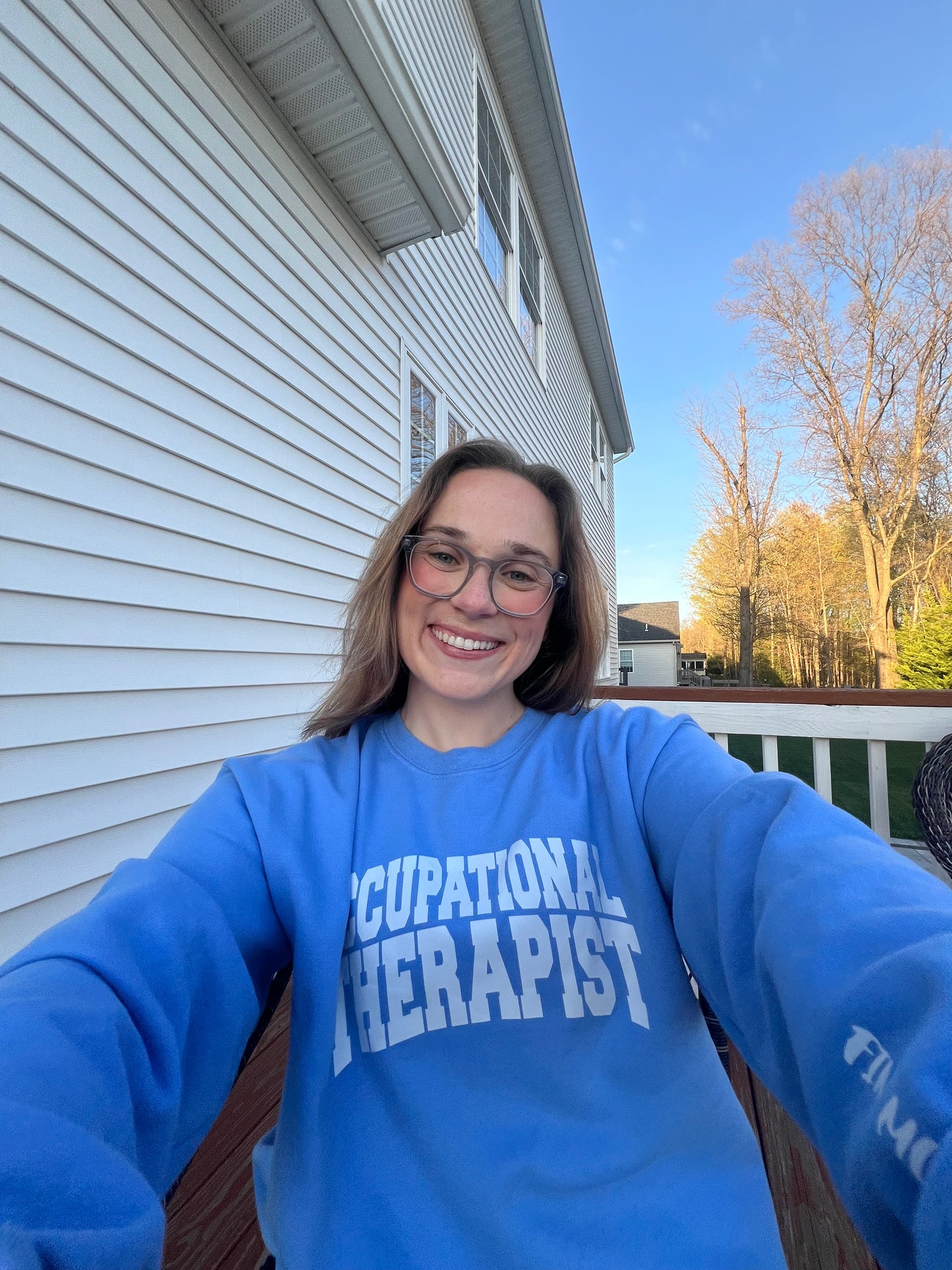 OT Haley Kelly wearing a blue Occupational Therapist sweatshirt designed by Ladyspinedoc.