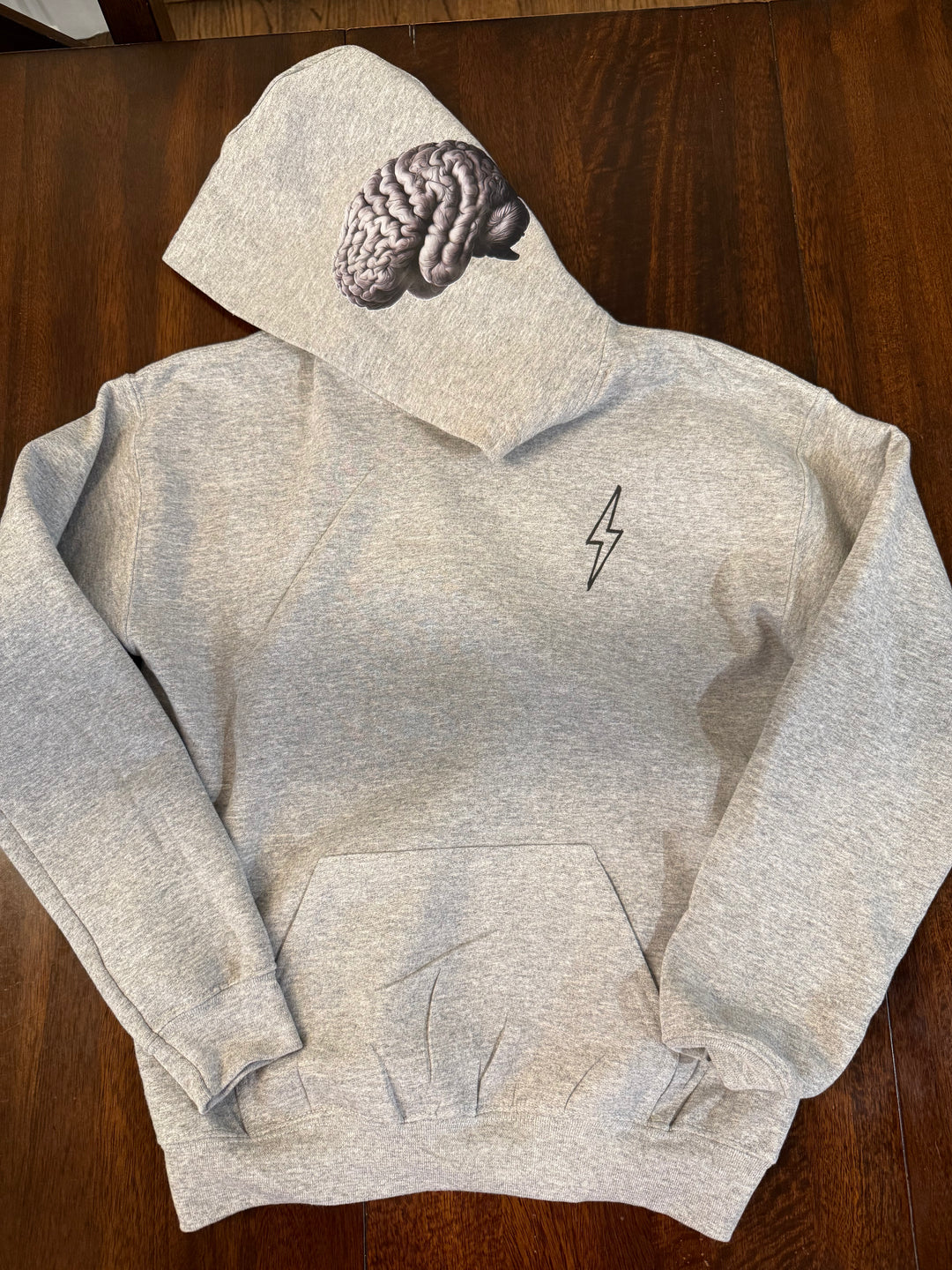 Light gray hoodie with a black lightning bolt on the upper left chest, brain design on left side of hood, and kangaroo pocket.