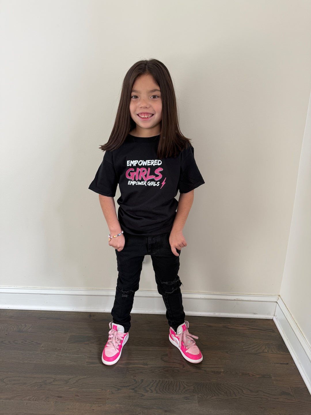 Ladyspinedoc's daughter wearing the Empowered Girls black tee shirt with the motto, "Empowered Girls Empower Girls."