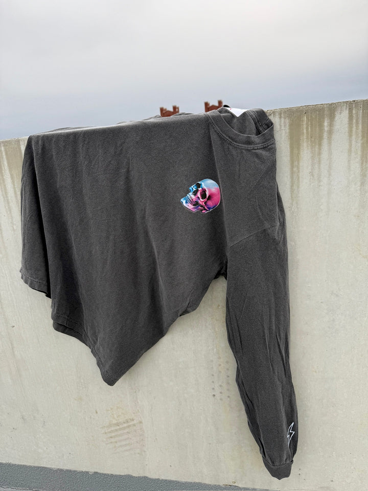 Skull Powers Long Sleeve Tee Shirt - Dark Gray with Skull and Lightning Bolt Design laying on a concrete wall