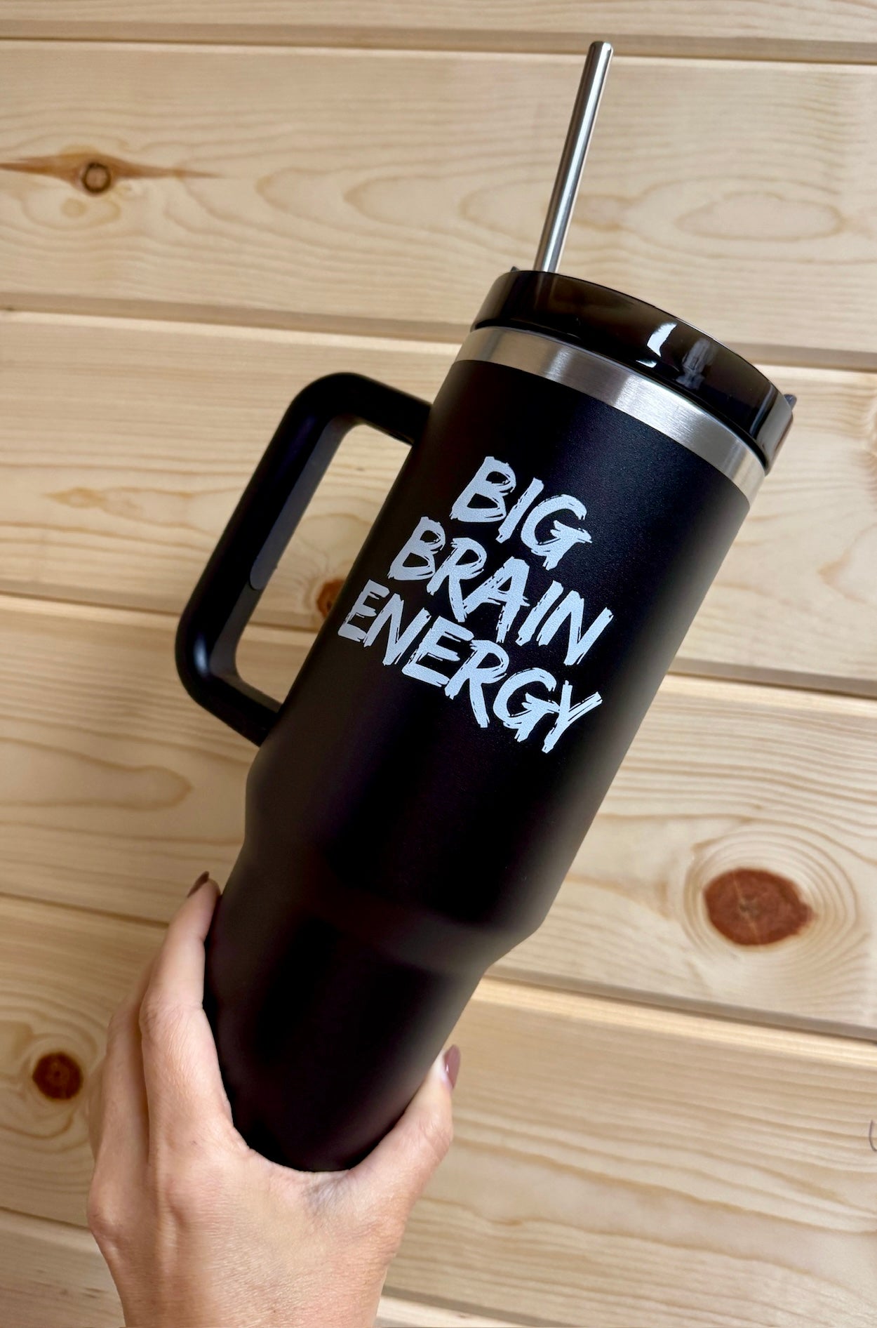 Hand holding the cup showing the 'BIG BRAIN ENERGY' design