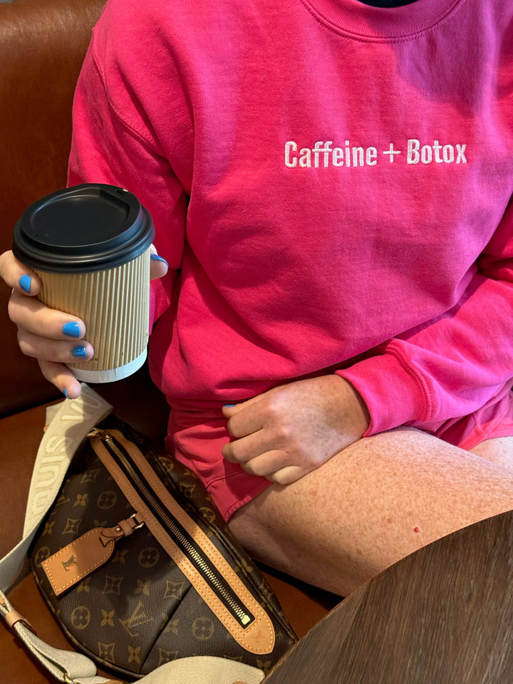 Ladyspinedoc wearing a pink sweatshirt with 'Caffeine + Botox' holding a coffee cup.