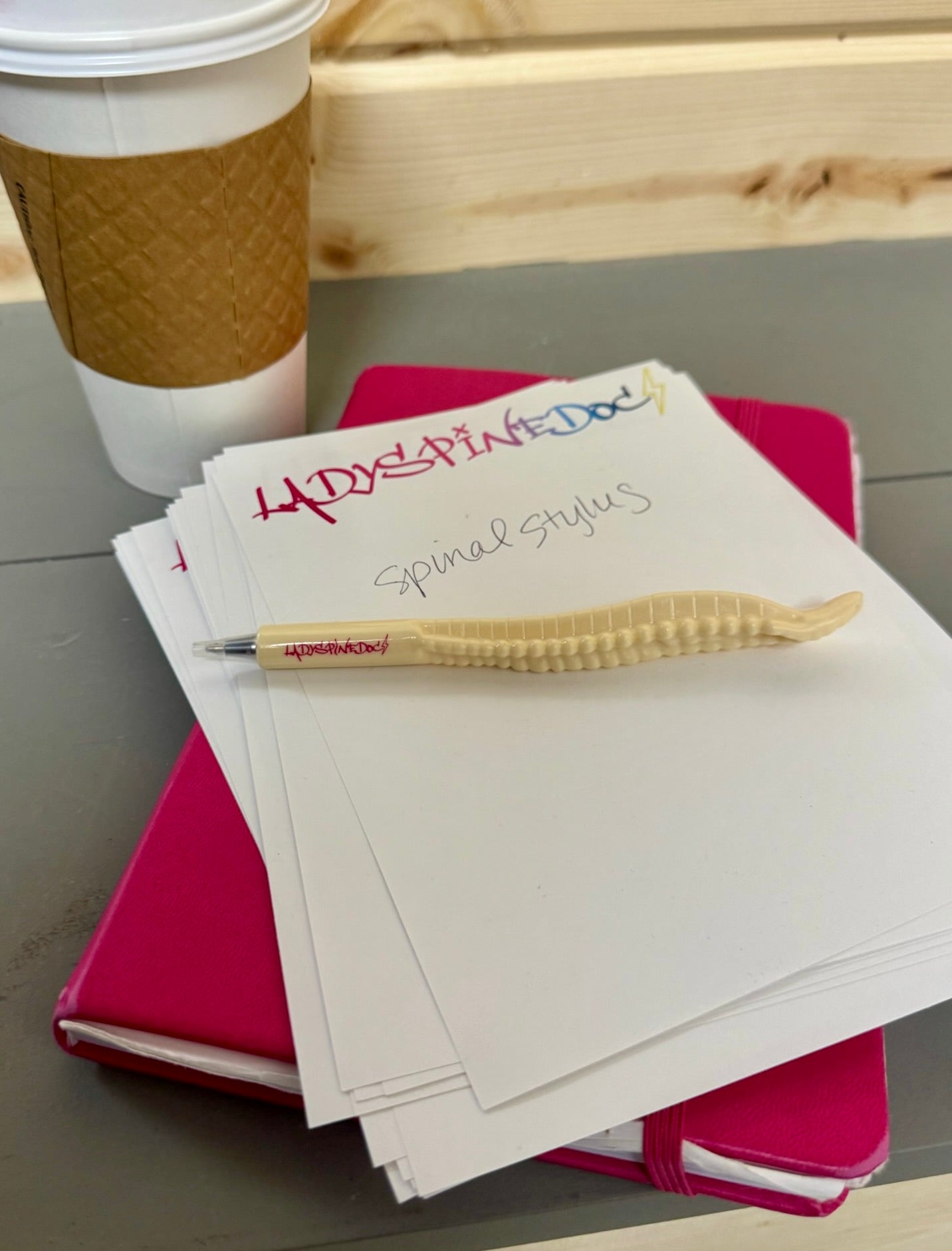 Spinal Stylus spine pen laying on Ladyspinedoc notepaper