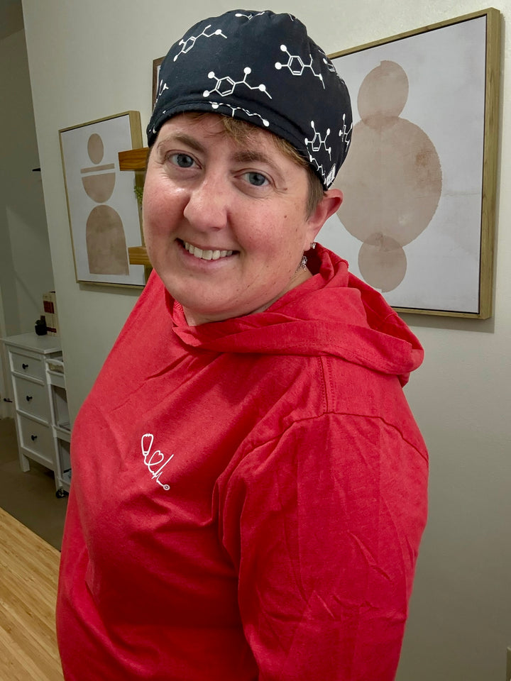 Side view of Dr. Beachgem wearing red Heart of Medicine long sleeve hooded tee