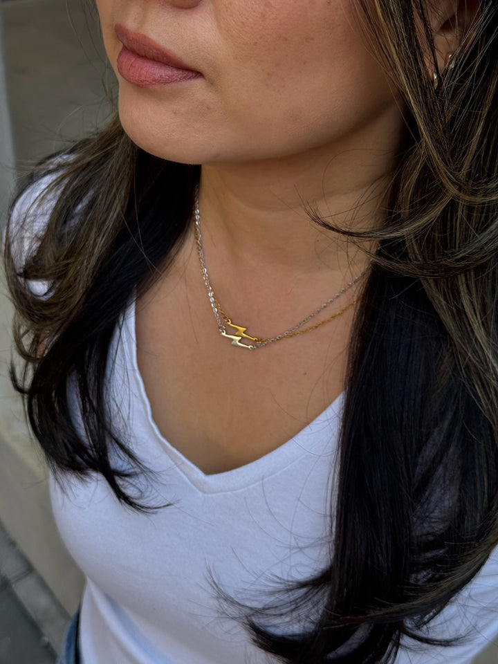 Model wearing gold and silver Ladyspinedoc Lightning Bolt necklaces