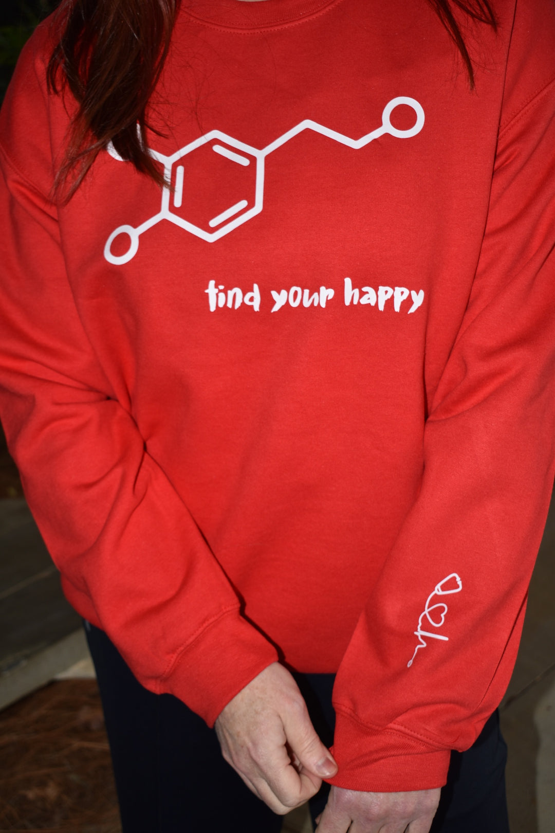 Dr. Betsy Grunch wearing the red Dopamine Molecule Sweatshirt, a cozy and stylish piece celebrating happiness and brain science.

