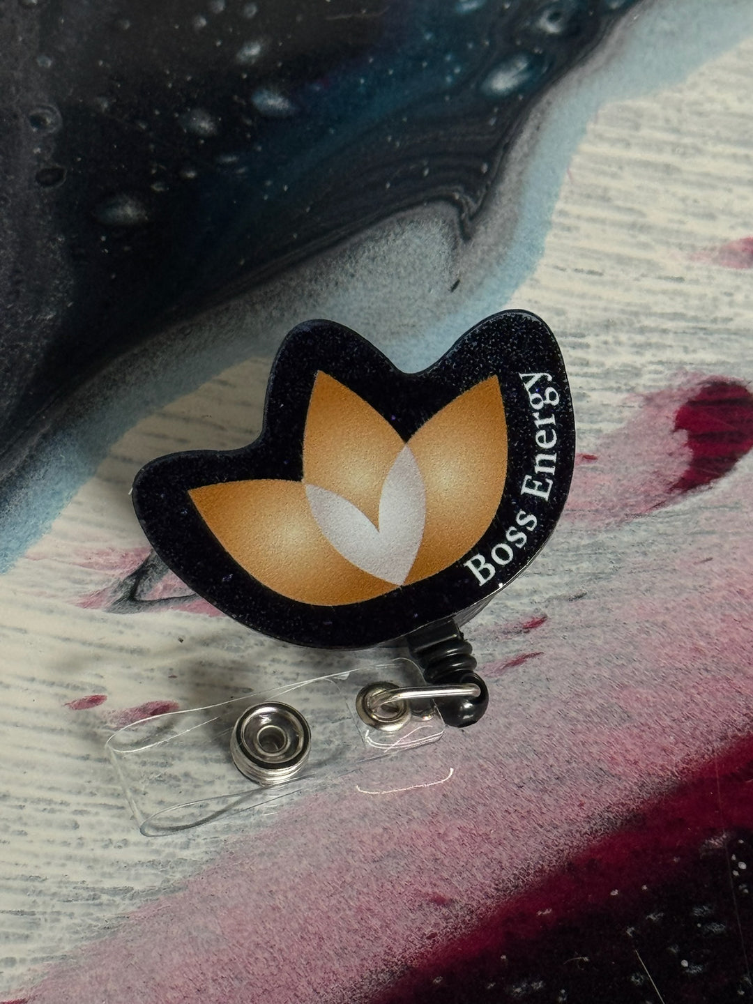 Boss Energy logo badge holder on a colorful surface