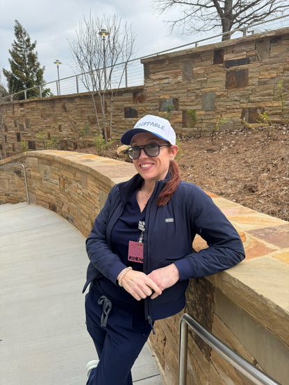 Dr. Betsy Grunch (Ladyspinedoc) wearing the blue and white UNSTOPPABLE Trucker Hat - ball cap with bold blue graffiti-style lettering.