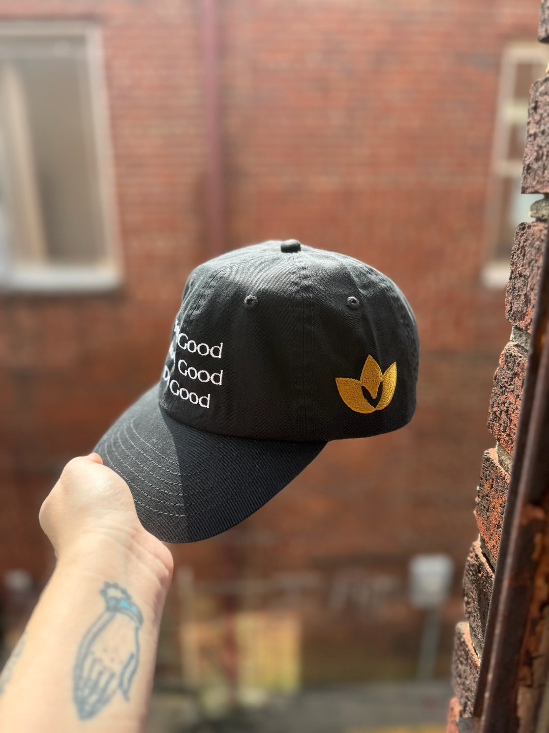 Feel Good, Look Good, Do Good black cotton ball cap showing embroidered motto on front and golden Confidence Doc logo on the side