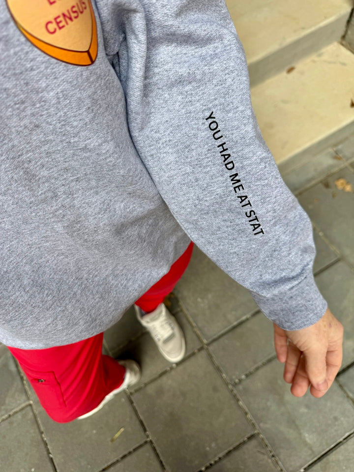Ladyspinedoc wearing a gray sweatshirt with You Had Me At Stat text on the sleeve, standing on a pavement.