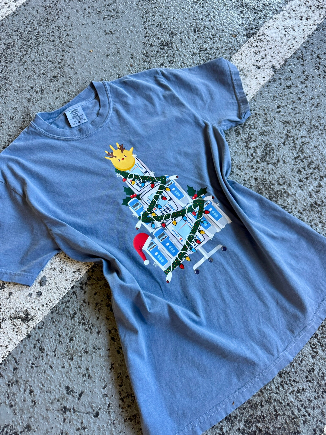 Blue Nurse Christmas Tree Tee Shirt with IV Pump Design on a concrete surface