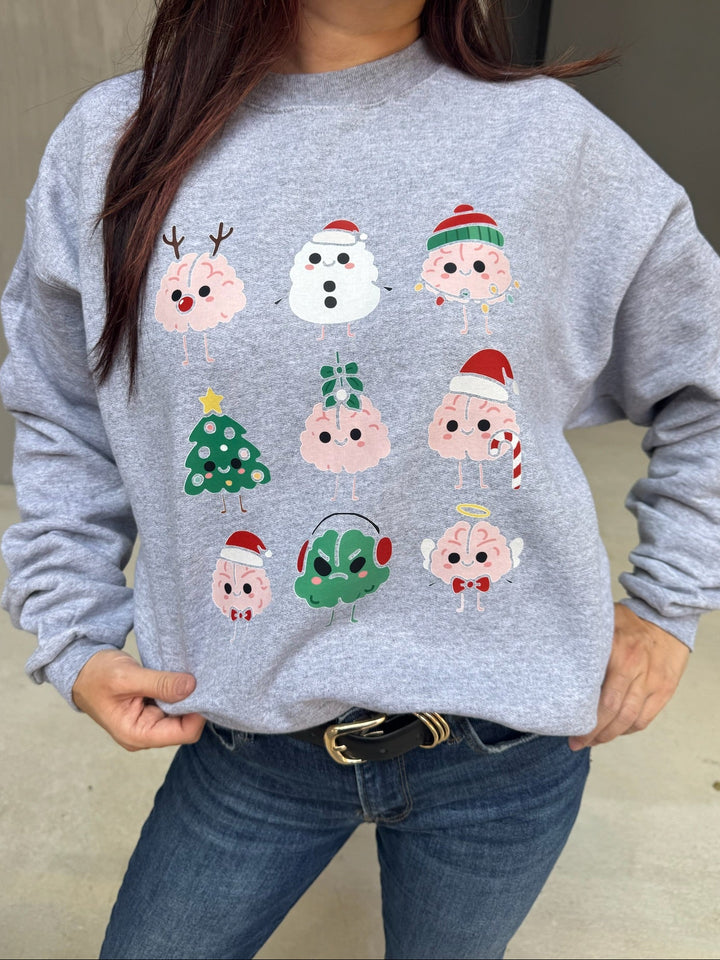 Person wearing a gray sweatshirt with Christmas Brain cartoon character designs.