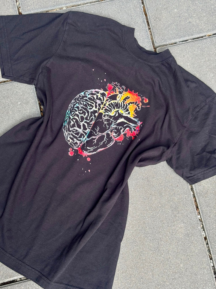 Flat lay of Synapse and Soul Crewneck Tee - Black T-Shirt with Brain | Heart Design on a sidewalk