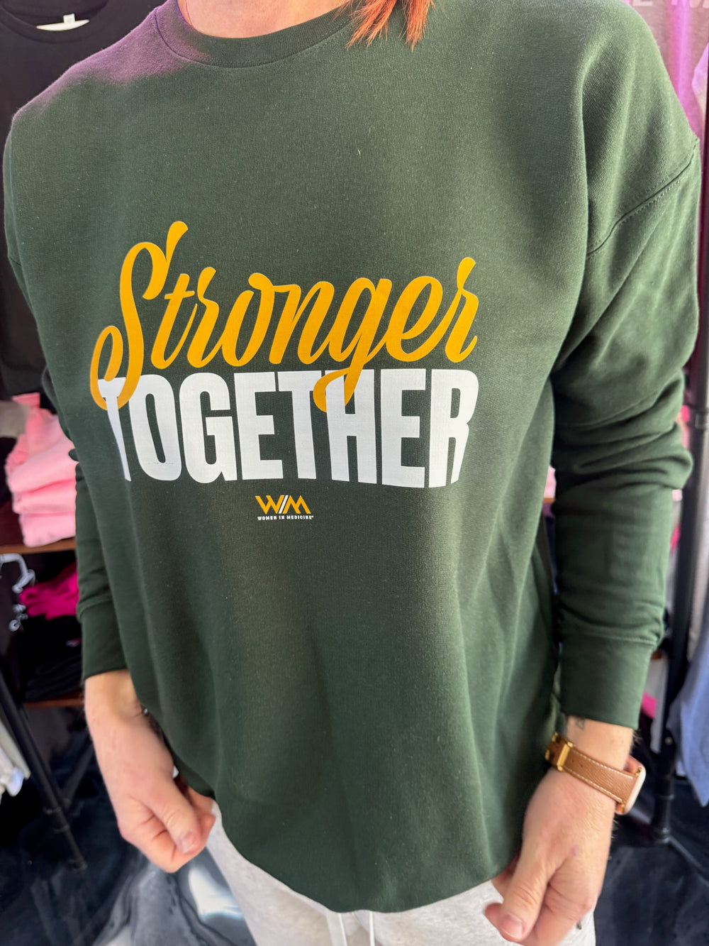 Green sweatshirt with 'Stronger Together' text and WM logo