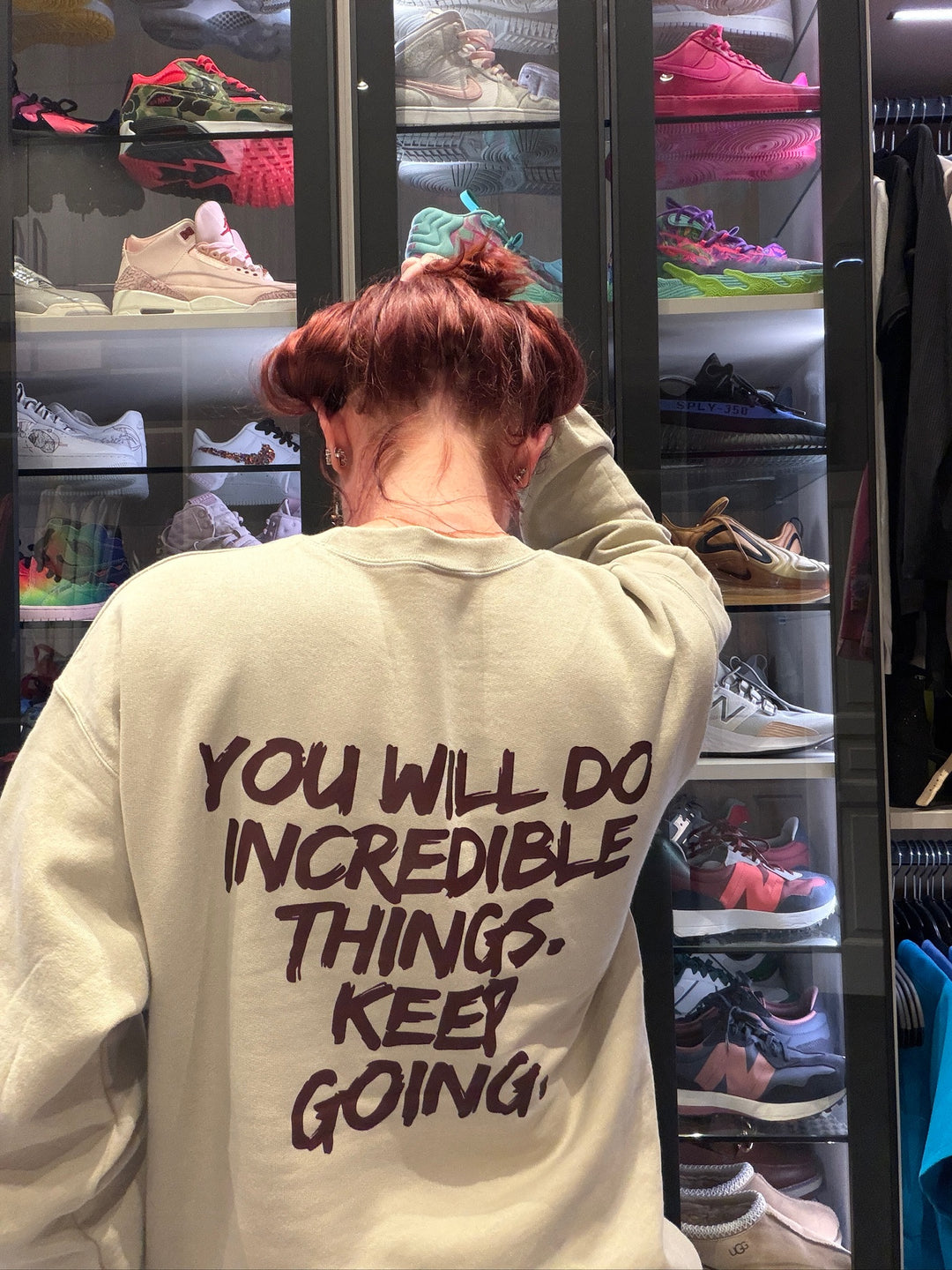 Ladyspinedoc wearing a sand-colored Incredible sweatshirt with motivational text: You Will Do Incredible Things. Keep Going on the back. 