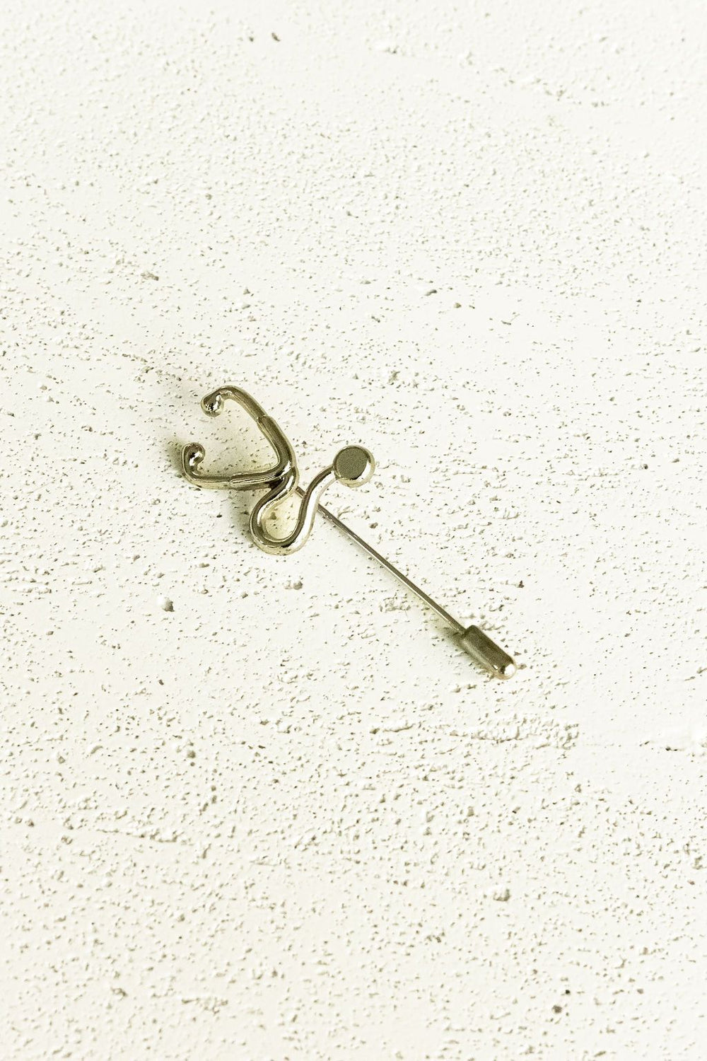 Silver Stethoscope Jacket Lapel Pin on a white surface