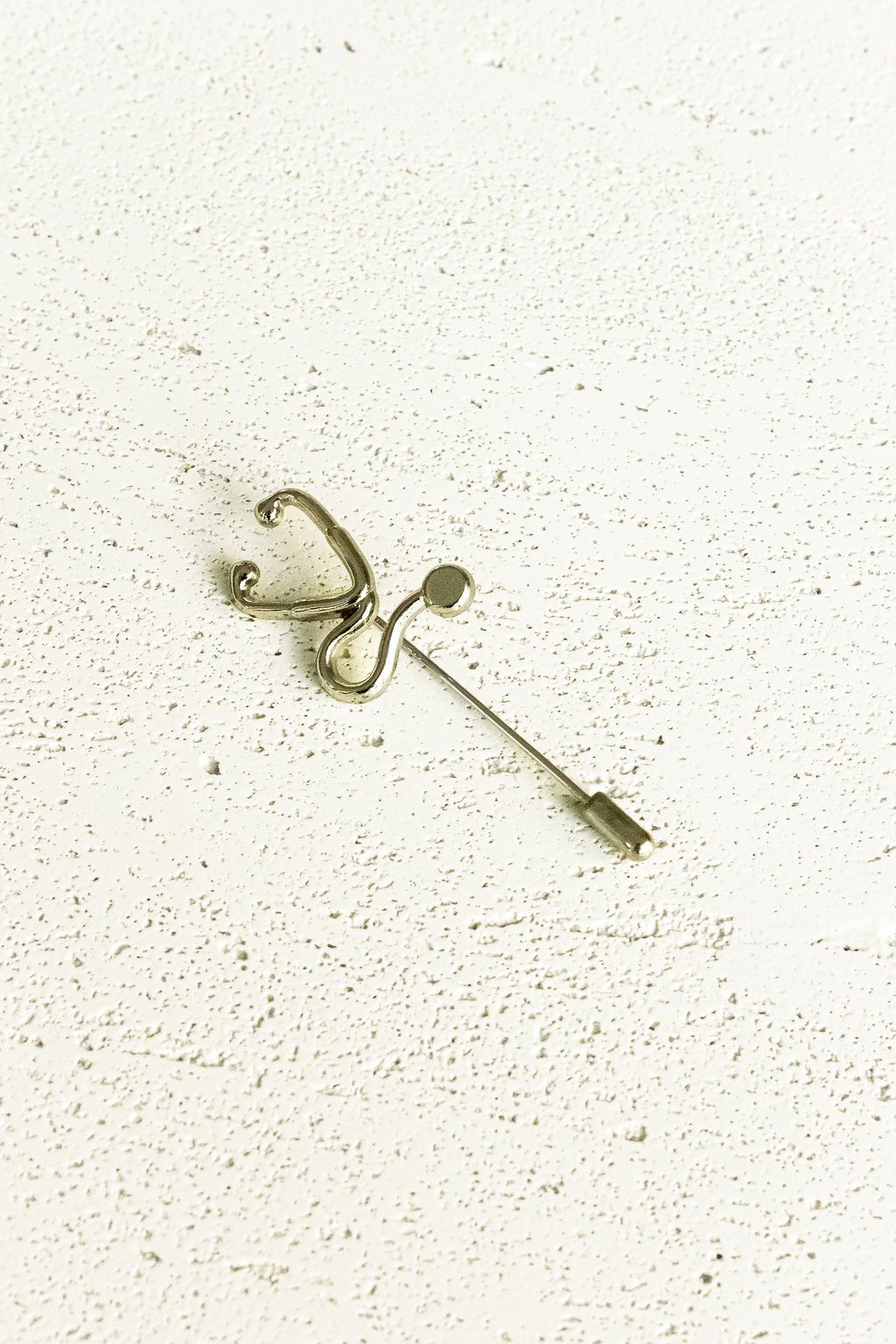 Silver Stethoscope Jacket Lapel Pin on a white surface