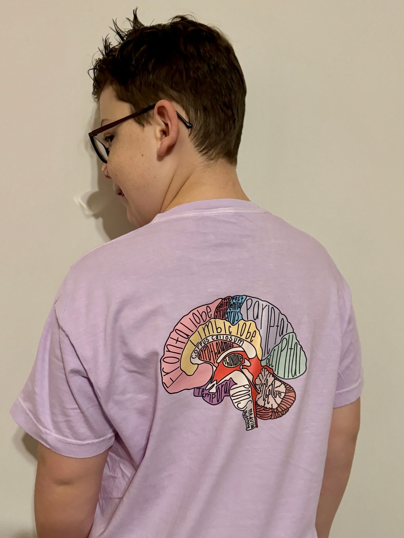 Boy showing off the back of the "I Lobe You" Brain Anatomy Tee with labeled parts of the brain