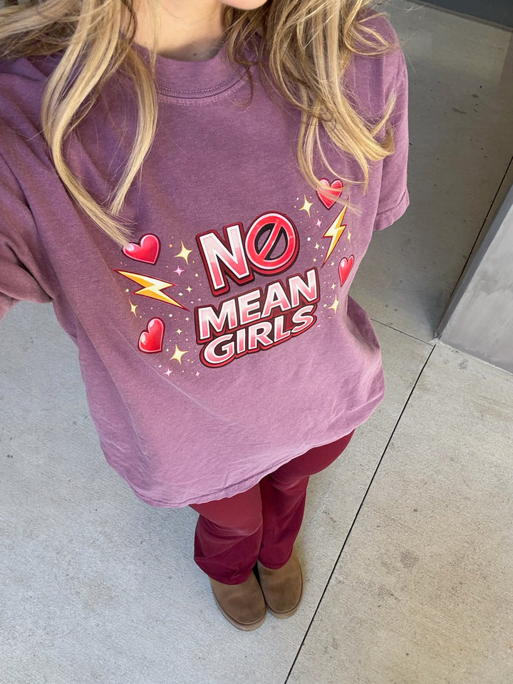 Person wearing a purple 'No Mean Girls' t-shirt in an indoor setting