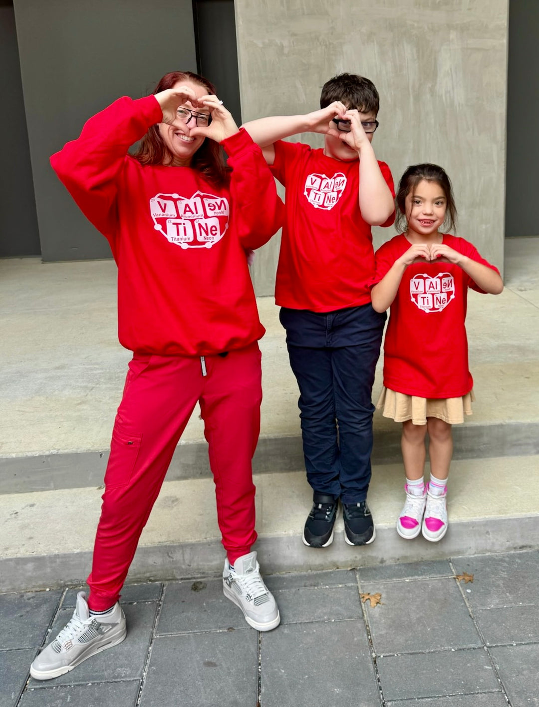 Ladyspinedoc and her kids wearing matching red Atomic Attraction Shirts with Periodic Table Valentine Design and posing on a sidewalk.