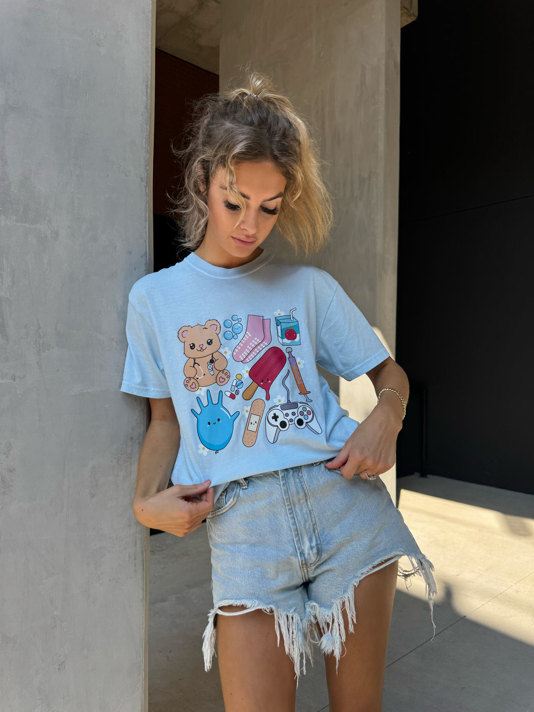 Model wearing light blue Ladyspinedoc x Scrubhacks Pediatrics Collage Tee Shirt