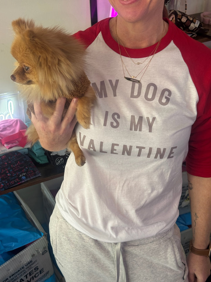 Ladyspinedoc wearing a shirt with 'My dog is my Valentine' holding a small brown dog.