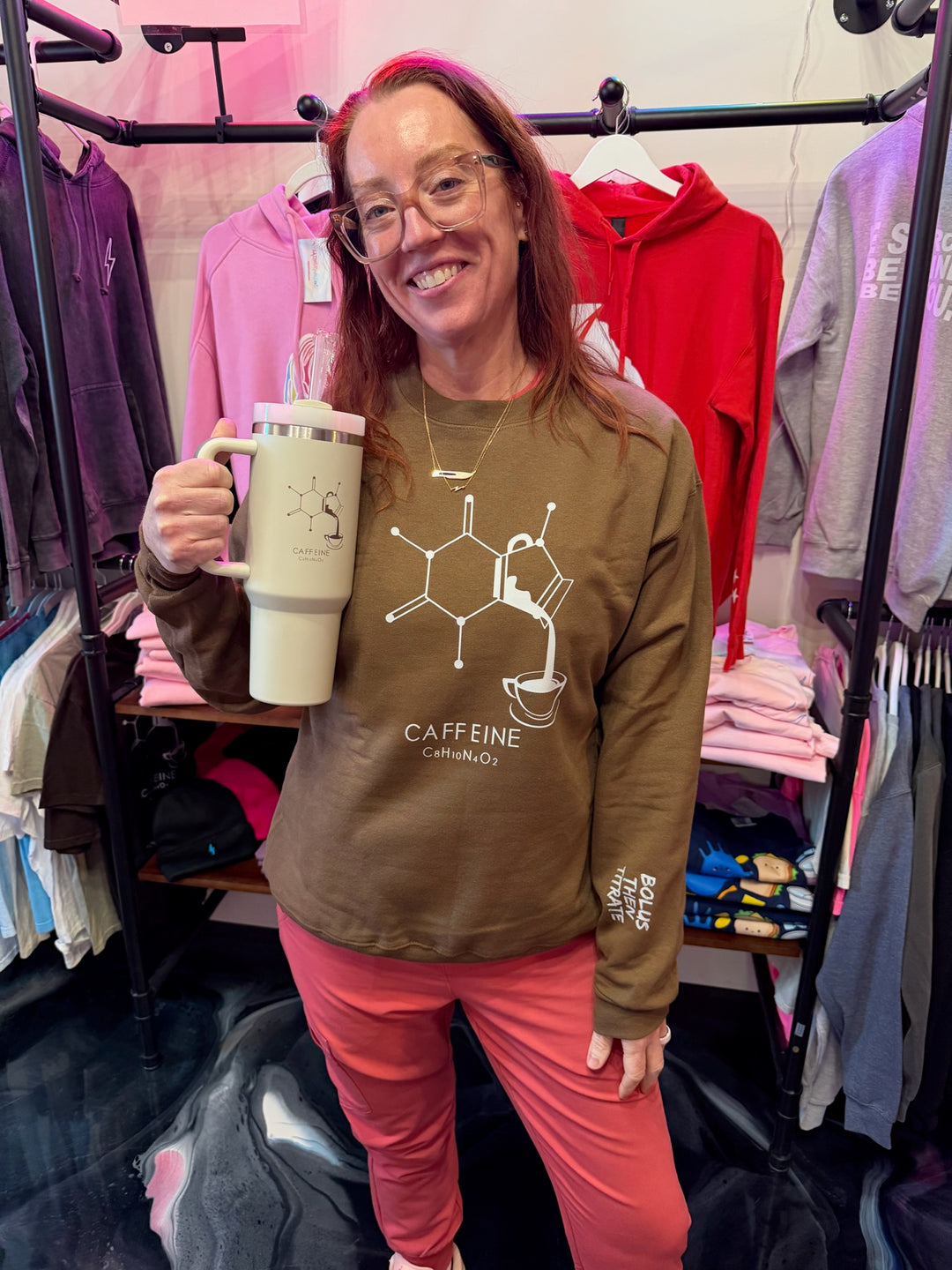 Ladyspinedoc holding Enerjava cup and wearing Enerjava Crewneck Sweatshirt - Brown Shirt with Caffeine Molecule Design for Coffee Lovers
