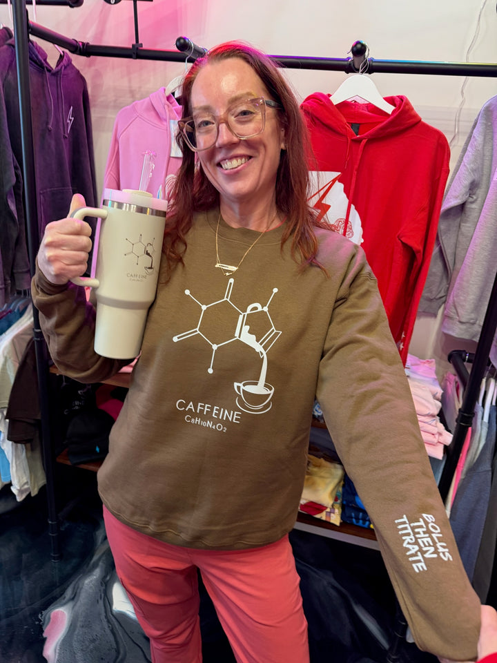 Dr. Betsy Grunch wearing Enerjava Crewneck Sweatshirt - Brown Shirt with Caffeine Molecule Design with Bolus Then Titrate on sleeve