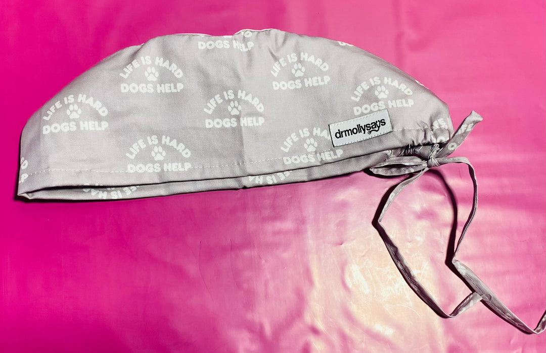 Gray scrub cap with white text on a pink background