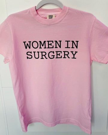 Pink t-shirt with 'WOMEN IN SURGERY' text on a white background