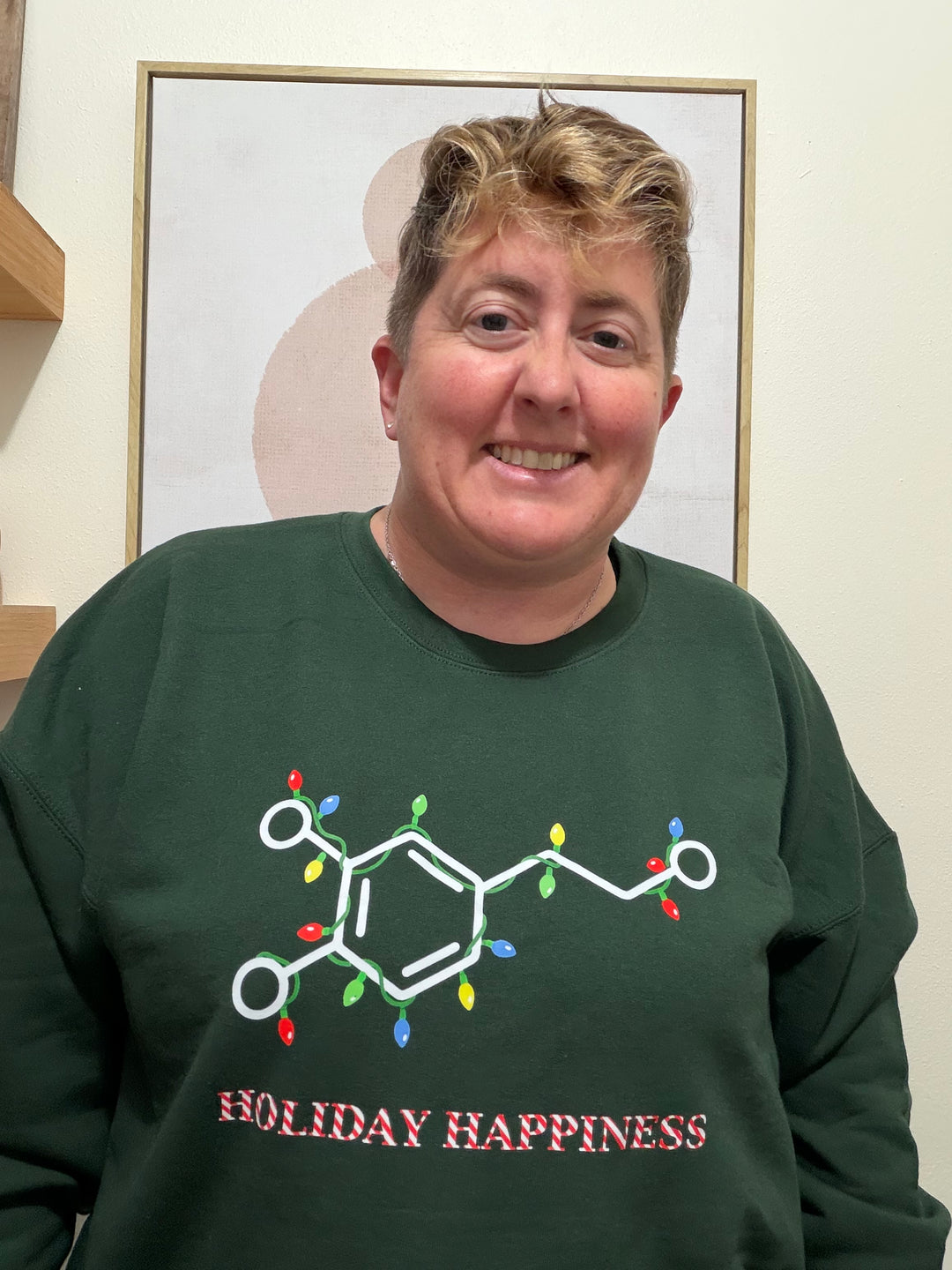 Dr. Beachgem wearing a green sweatshirt with chemical structure design and 'Holiday Happiness' text.