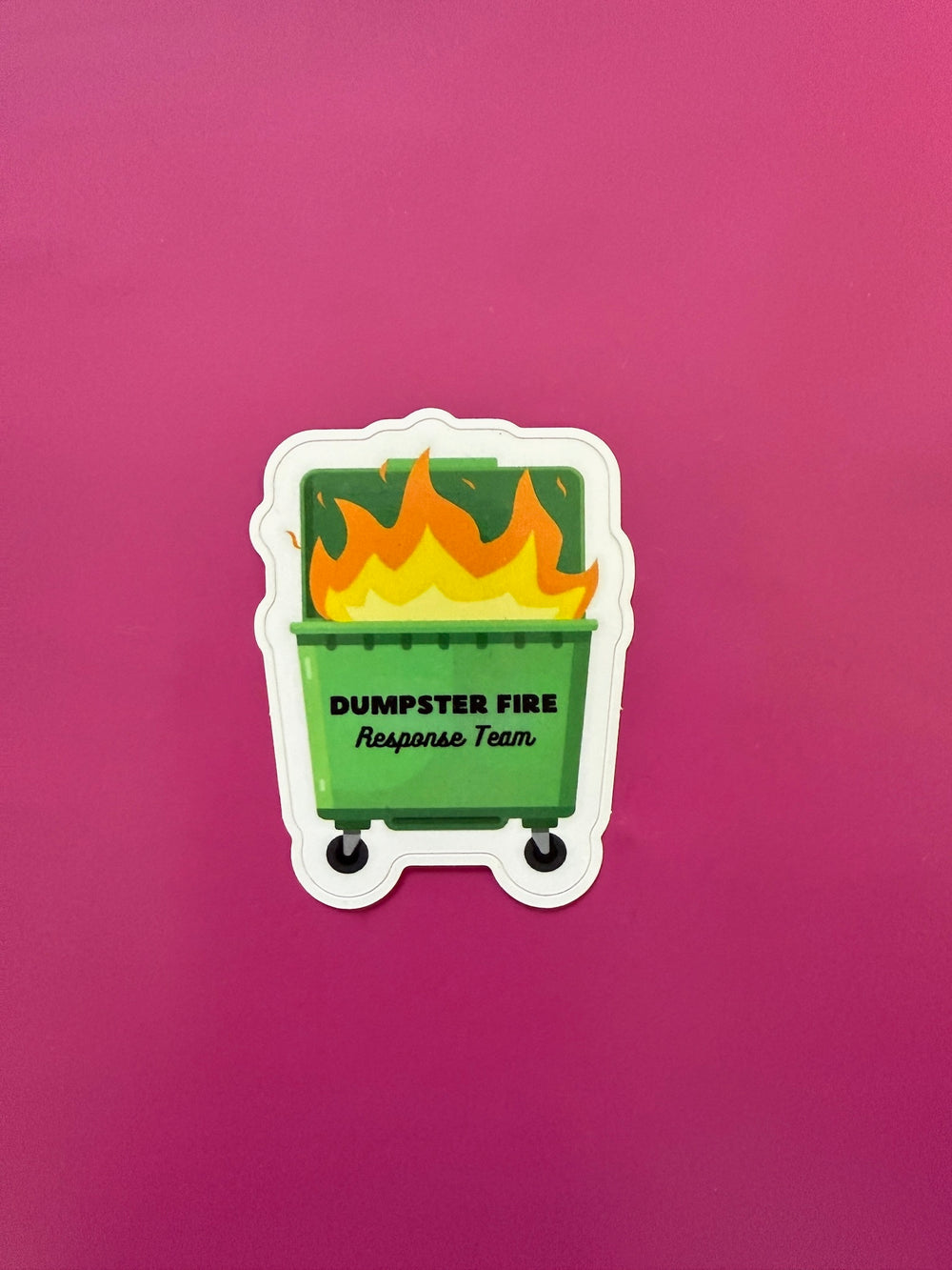 Sticker of a green dumpster with flames and 'Dumpster Fire Response Team' text on a pink background