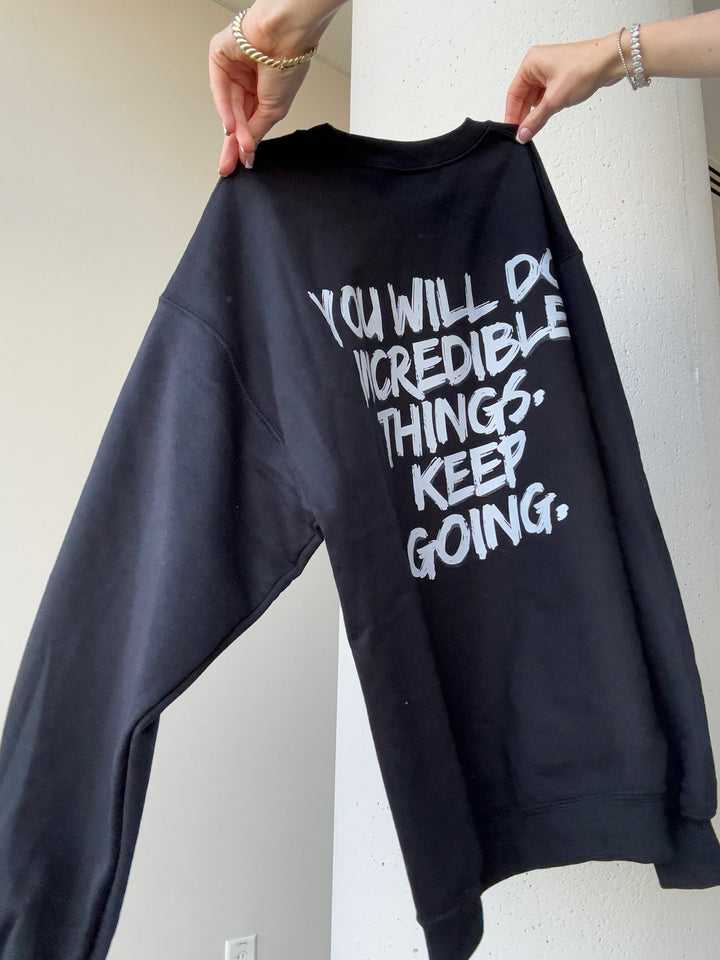 Back view of sweatshirt with bold white brushstroke message: "YOU WILL DO INCREDIBLE THINGS. KEEP GOING."

