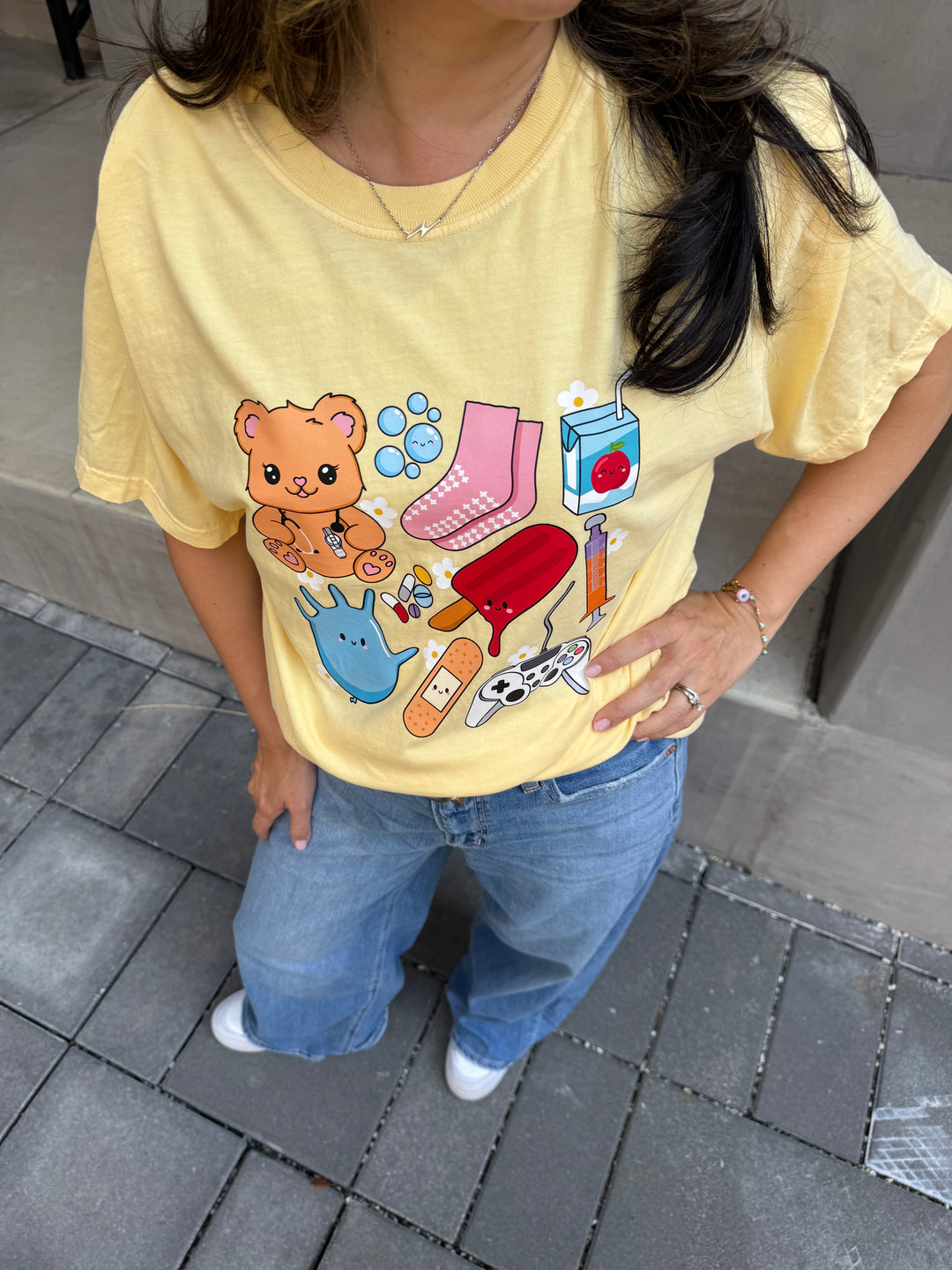 Close up view of collage design of yellow Ladyspinedoc x Scrubhacks Pediatrics Collage Tee Shirt 