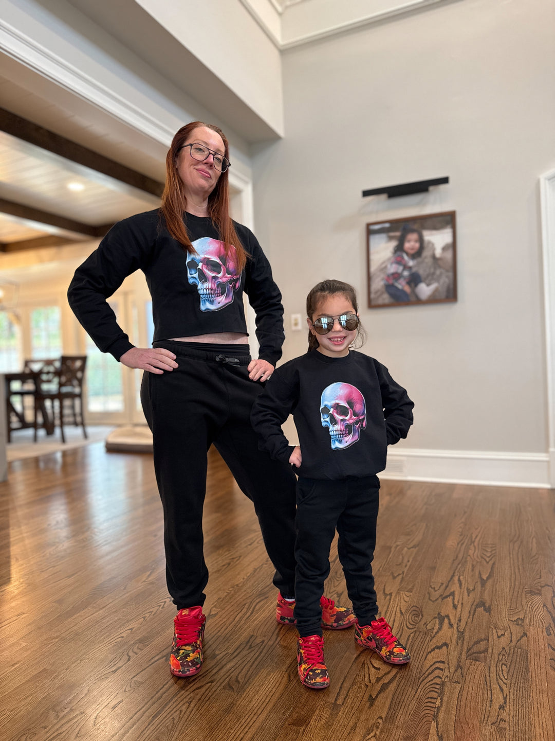 Dr. Betsy Grunch wearing the Super Skull Cropped Crewneck Sweatshirt - Black Crop Top Shirt with Skull Design. Her daughter is wearing the Youth Super Skull Crewneck Sweatshirt. 
